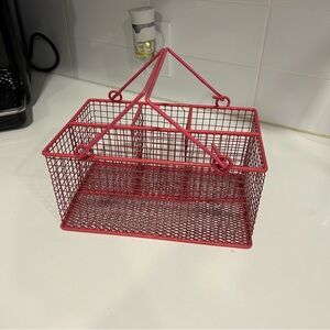 Small pink metal wire organizer with compartments and handles for utensils